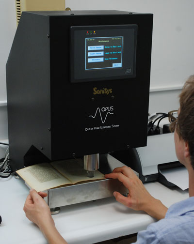 Person analyzing an open book page in the SoniSys OPUS Z-direction ultrasonic tester